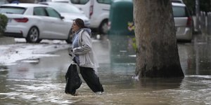 Γυναίκα περπατά σε πλημμυρισμένο δρόμο