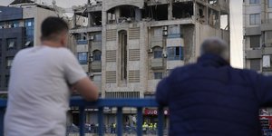 Πολίτες του Λιβάνου κοιτάζουν τα κατεστραμμένα από τους ισραηλινούς βομβαρδισμούς κτίρια