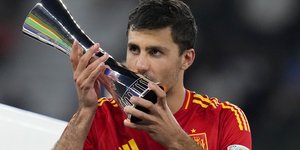 Ο Ισπανός Ρόδρι φιλάει το τρόπαιο του Καλύτερου Παίκτη του Euro 2024 μετά τον τελικό μεταξύ Ισπανίας και Αγγλίας 