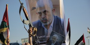 Ενοπλοι κρατούν αφίσα του Σινουάρ