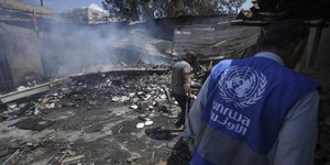 Άνδρας της UNRWA στα χαλάσματα κτιρίου μετά από βομβαρδισμό στη Γάζα