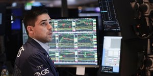 Άνδρας αγωνιά μπροστά από οθόνες με χρηματιστηριακούς δείκτες