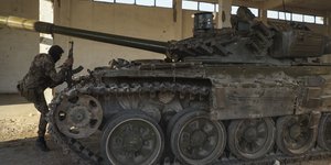 Ένας μαχητής της συριακής αντιπολίτευσης ανεβαίνει σε ένα εγκαταλελειμμένο τεθωρακισμένο όχημα του συριακού στρατού