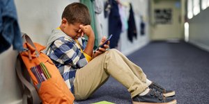 Παιδί στενοχωρημένο με κινητο στο σχολείο