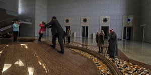Σύριοι βγάζουν αναμνηστικές φωτογραφίες με το κινητό τους τηλέφωνο μέσα στο Προεδρικό Μέγαρο μετά την κατάρρευση της συριακής κυβέρνησης στη Δαμασκό, Κυριακή 8 Δεκεμβρίου 2024