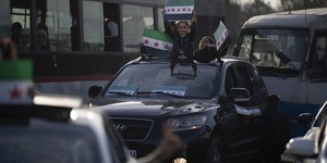 Κορίτσια κρατούν σημαίες της συριακής αντιπολίτευσης μετά την πτώση της κυβέρνησης του Μπασάρ Άσαντ στη Δαμασκό