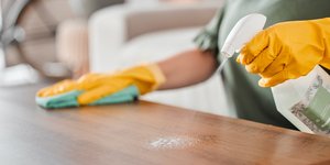 Γυναίκα καθαρίζει και απολυμαίνει επιφάνεια