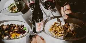 Τραπέζι στρωμένο πιάτα φαγητά κρασί μπουκάλι Ασωτος Παγκράτι Aθήνα