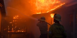 Πυροσβέστες επιχειρούν σε σπίτι στην περιοχή Altadena της Καλιφόρνιας