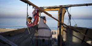 Γυναίκα με το παιδί της στο κατεστραμμένο σπίτι τους στην Γάζα