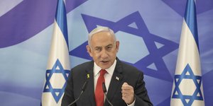 Ο Μπέντζαμιν Νετανιάχου ανάμεσα σε σημαίες του Ισραήλ