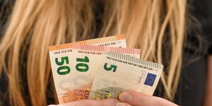 Γυναίκα μετρά την αμοιβή της σε ευρώ