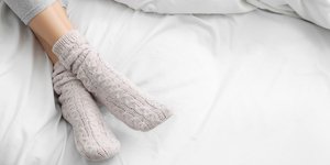 Γυναικεία πόδια με κάλτσες στο κρεβάτι 