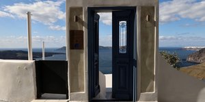 Πόρτα με θέα τη νέα Καμμένη στην καλντέρα της Σαντορίνης