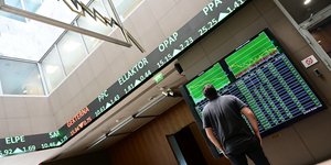Ανδρας κοιτάζει τους δείκτες του χρηματιστηρίου