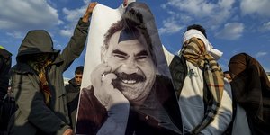 Υποστηρικτές του PKK κρατούν αφίσα του Οτσαλάν