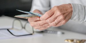 Ηλικιωμένο άτομο μετρά χρήματα σε ευρώ