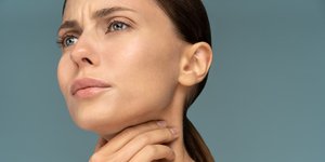 Γυναίκα κρατά τον λαιμό της