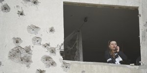 Γυναίκα στο Χάρκοβο μιλά στο τηλέφωνο μέσα από βομβαρδισμένο οίκημα