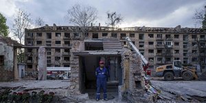 Διασώστης μπροστά από συντρίμμια κατοικιών στο Κίεβο, μετά από ρωσικό βομβαρδισμό