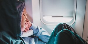 Κοπέλα με φούτερ κοιμάται στο αεροπλάνο