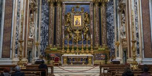 Πιστοί κάθονται μπροστά σε μια εικόνα της Παναγίας στη Βασιλική της Santa Maria Maggiore