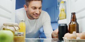 Άνδρας παίρνει ανοιχτή κονσέρβα από το ψυγείο