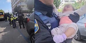 Αστυνομικός κρατάει το βρέφος στην αγκαλιά του