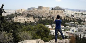 Νέος άνδρας φωτογραφίζει τον βράχο της Ακρόπολης στην Αθήνα
