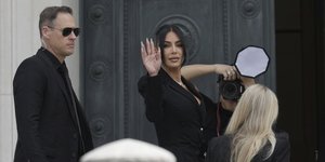 Η Κιμ Καρντάσιαν χαιρετά το συγκεντρωμένο πλήθος έξω από το δικαστήριο του Παρισιού