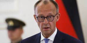 Ο Φρίντριχ Μερτς μπροστά από τη γερμανική σημαία