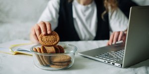 Μαθήτρια που διαβάζει και τρώει μπισκότα / Φωτογραφία: shutterstock