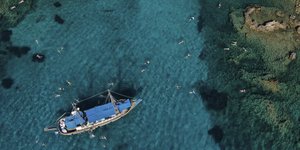 Λουόμενοι σε νερά του Ιουνίου πελάγους, δίπλα σε τουριστικό σκάφος