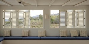 σαλόνι παράθυρα στόρια λευκά μπλε μαξιλάρια 