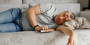 Άνδρας παίρνει έναν υπνάκο σε καναπέ