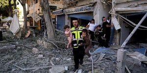 Ανδρας βγάζει παιδιά από κτίριο που βομβαρδίστηκε στη Χάιφα