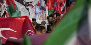 Οπαδοί του καθεστώτος του Ιράν με σημαίες και αφίσα του Αγιατολάχ Αλί Χαμενεΐ