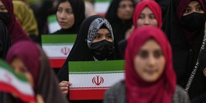 Γυναίκες στο Πακιστάν εκφράζουν την αλληλεγγύη τους στο Ιράν, κρατώντας σημαίες της χώρας 