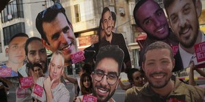 Συγγενείς των ομήρων που κρατά η Χαμάς σηκώνουν πλακάτ με τα πρόσωπά τους