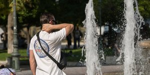 Άνδρας κάθεται μπροστά από συντριβάνι