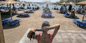 Γυναίκα κάνει ντους στην παραλία
