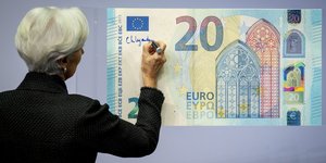 Η επικεφαλής της ΕΚΤ, Κριστίν Λαγκάρντ υπογράφει πάνω σε ένα τεράστιο μοντέλο 20ευρου χαρτονομίσματος