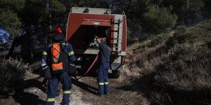 Πυροσβέστες πίσω από πυροσβεστικό