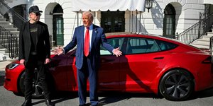 Ντόναλντ Τραμπ και Έλον Μασκ μπροστά από το κόκκινο Tesla του προέδρου των ΗΠΑ