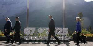 Ο Ντόναλντ Τραμπ αποχωρεί από το σημείο της φωτογράφισης των ηγετών της G7, πίσω του οι Στάρμερ, Μερτς και Φον ντερ Λάιεν
