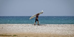 Άνδρας με σανίδα στην παραλία