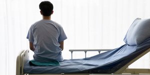 Ασθενής κάθεται στο κρεββάτι του Νοσοκομείου