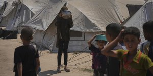 Εκτοπισμένοι Παλαιστίνιοι περιμένουν τρόφιμα που τους δόθηκαν σε μια κοινοτική κουζίνα στην πόλη της Γάζας, στο βόρειο τμήμα της Λωρίδας της Γάζας,