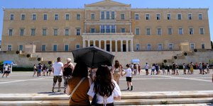 People walks in the streets during a hot day in central Athens