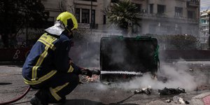 Πυροσβέστης σβήνει φωτιά από κάδο